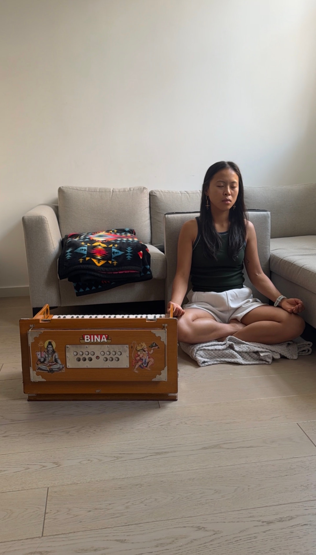 Caryn sitting in meditation beside her harmonium