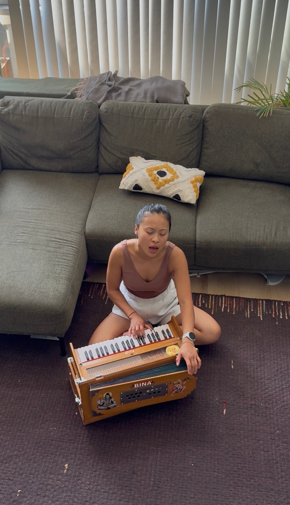 Caryn chanting and playing the harmonium at home